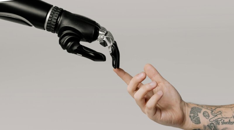 A human hand reaching out to a robotic hand, representing the connection between human creativity and artificial intelligence detection tools like Sapling AI.